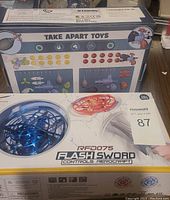 Box of Take Apart Toys showing various components including propellers, screws, and discs, illustrating the parts included in the set.