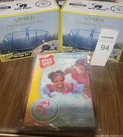 Two boxed Vmini trampoline sprinklers and one packaged Play Day arm floaties set with two armbands.