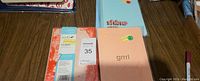 Set of 6 assorted writing journals arranged on a wooden surface showing variety of colorful covers and texts