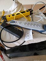 All three power bars displayed on a table showing cords and overall condition