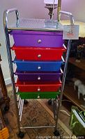 Front full view of art trolley showing colorful drawers and metal frame on wheels.