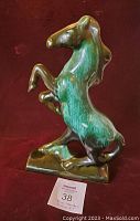 Full side view of the Blue Mountain Pottery horse figurine showing the horse rearing on its hind legs in green and brown glaze.