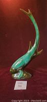 Full view of the tall fish figurine showing its upward curved tail and colors