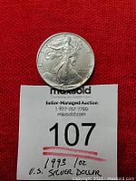 Obverse of 1993 1 oz silver dollar showing Lady Liberty walking with sun and inscription details. Coin positioned above auction tag with lot number and description.