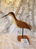 Full view of the folk art hand carved shore bird figurine showing painted details and mounted wooden base.