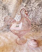 Photo of lavender pink pressed glass hen candy dish and porcelain egg trinket box on lace background.