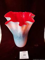 Front view of the hand-blown glass handkerchief vase showing red interior and blue/gray exterior on black background.