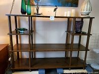 Full front view of the Mid-Century Modern wooden shelving unit, displaying its open grid structure and three wooden shelves with a warm brown finish.