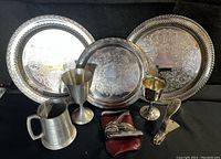 Wide view of all memorabilia including trays, cups, and metal clip, showing condition and arrangement.