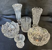 Full view of six piece crystal glass collection showing varied shapes and cut patterns including sawtooth, checkerboard rose, hobstar starburst designs.