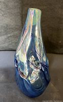 Front angled view showing iridescent blue glass, organic shape, smooth surface.