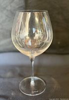 Side view of clear Luigi Bormioli red wine glass showing its tall slender stem and round bowl.