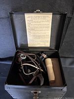 Open metal carrying case showing signal light wiring, coiled cord, and instructions inside lid