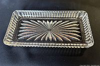 Top-down view of clear rectangular lead crystal vanity tray showing starburst patterned base and ribbed edges.