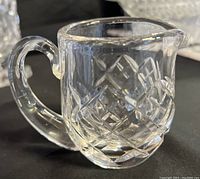 Front angled view showing handle, spout, and cut crystal pattern of mini creamer pitcher.