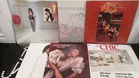Seven vinyl record albums displayed showing album artwork and artists including Robert Plant, Dionne Warwick, Barbra Streisand and Barry Gibb, Three Dog Night, The Monkees, Chic, and All That Jazz soundtrack.