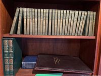 Overview of two shelves showing 28 green Chronicles of Canada volumes on top and 4 Audubon books on bottom