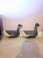 Front view of two wooden duck decoys showing overall shape and paint wear