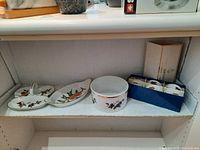 Shelf with all 9 Evesham serving dish pieces including bowls, plates, and boxed small dishes.