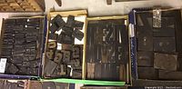 Four boxes of antique wood printer's letters arranged side by side showing the variety in letter sizes and quantities in each box.