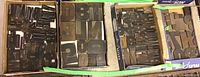 Four cardboard boxes filled with wood type blocks arranged side by side
