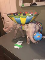 Side view of two-elephant sculpture supporting removable bowl