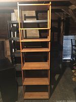 Tall wooden shelf unit with multiple shelves in a garage setting