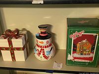 Photo of three Christmas cookie jars: gift box style, snowman, and boxed Ralphie's House jar.