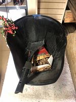 Black plastic ash bucket with a black scoop and a box of fire starters inside it, on a white cloth.