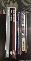Side view of comic books, showing titles including Dark Avengers, A Galaxy of War, Valiant, Unity Saga Volume One, Marvel Comics, and X-Men comics.