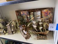 Overall view of multiple copper decorative pieces, including ship, train, and mounted wall art
