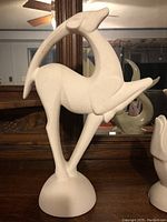 Side view of the white textured gazelle sculpture showing form and texture.