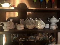 Full shelf view showing cups, saucers, teapot, sugar bowl, creamer, and candle holders in Shamrock pattern