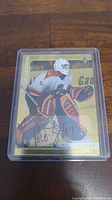 Front view of Roberto Luongo autographed hockey card with player in goalie posture and visible signature.