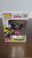 Front clear window box view of Witch Doctor Funko Pop figure inside its packaging.