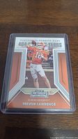 Front view of Trevor Lawrence rookie card showing player image, team colors, and Panini Contenders branding.