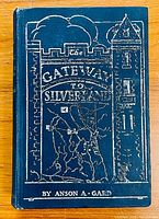 Front cover of the book 'The Gateway to Silverland' showing blue cover with silver embossed title and design.