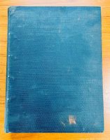 Front cover of bound journal with dark green textured cloth, light wear and minor discoloration visible.
