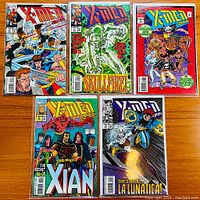 Front covers of four Uncanny X-Men comic book issues #187, #208, #209, and #214 showing colorful action artwork and Marvel/Comics branding.