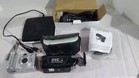 Lot showing Canon PowerShot A95, silver compact camera, DVC video camera, boxed microphone, battery charger and carrying case