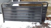 Pair of black DK2 trailer gates positioned on the ground, showing full front and rear gates with visible wear.