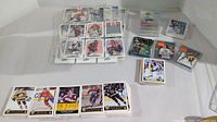 Overview of multiple stacks and piles of hockey trading cards, including base cards in pages, loose piles, and small stacks in penny sleeves