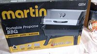 Box showing Martin brand and model GR14 with image of the portable propane BBQ and key features