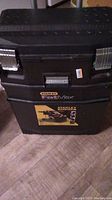 Stanley FatMax three-level mobile tool box closed, showing metal latches and handle on black plastic body