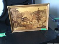 Front view of hand inlaid wood veneer artwork showing rural house scene and forest landscape.