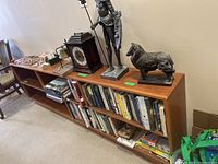 Photo showing the full bookcase with books on all shelves and several decorative items on top.