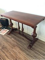 Full side view of the rectangular wooden hallway table showing double pedestal legs and top surface.