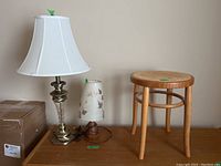 Photo shows two lamps and a stool on a table against a neutral background, illustrating relative sizes and styles.