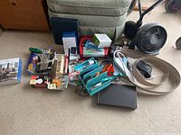 Overview of various office items including scissors, tape, nail kit, extension cords, and desk fan.