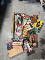 Overview photo showing a collection of vintage Christmas decorating items including boxed string lights, a floodlight, packaging, and a cardboard tube.